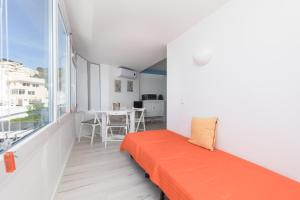 a bedroom with an orange bed and a large window at Apartamento Sol da Falésia in Sesimbra