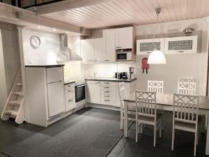 a kitchen with white cabinets and a table and chairs at Tahkonloft in Tahkovuori