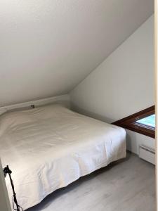 a white bed in a room with a window at Tahkonloft in Kuopio