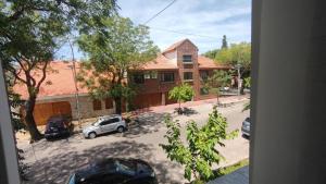 a house with cars parked in a parking lot at Departamento en excelente área in Villa Marini