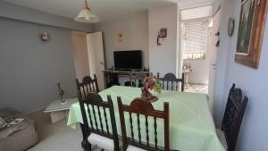 a dining room with a green table and chairs at Departamento en excelente área in Villa Marini