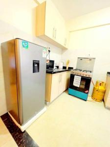 a kitchen with a stainless steel refrigerator and a stove at Cozy Two Bedroom Apartment in Nairobi