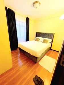 a bedroom with a bed and a wooden floor at Cozy Two Bedroom Apartment in Nairobi