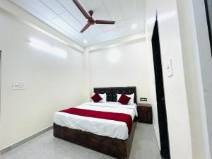 a bedroom with a bed with a ceiling fan at The Lord Krishna Residency Vrindavan in Vrindāvan