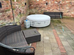 a patio with a white dog bed and a bench at The Little Hexthorpe house in Doncaster