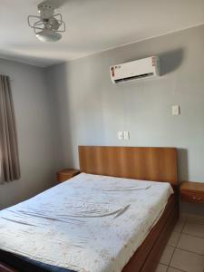 1 dormitorio con 1 cama y aire acondicionado en la pared en Jardins das Thermas Caldas Novas perto do Clube Privê, en Caldas Novas