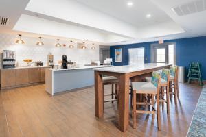 uma cozinha com paredes azuis e uma mesa e cadeiras em La Quinta by Wyndham Shawnee em Shawnee