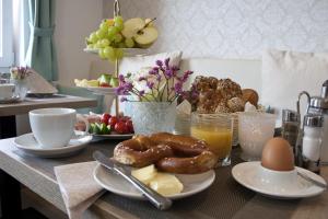 einen Frühstückstisch mit Brezeln und anderen Frühstückszutaten in der Unterkunft Hotel Claro Garni in Eitting
