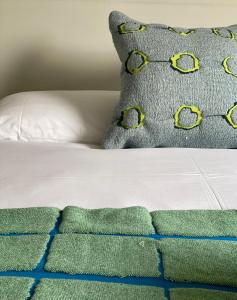 a bed with a pillow and a green and blue blanket at Kylesku Lodges in Kylestrome