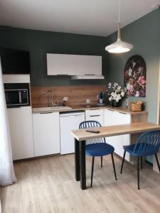 uma cozinha com uma mesa e duas cadeiras e uma mesa e um balcão em Studio neuf-Wintzenheim-proche Colmar-Parking em Wintzenheim