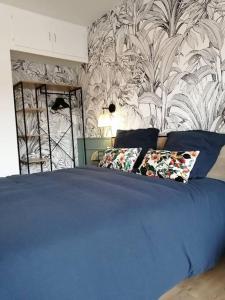 uma cama azul com duas almofadas num quarto em Studio neuf-Wintzenheim-proche Colmar-Parking em Wintzenheim