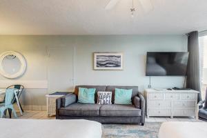 a living room with a couch and a tv at Top of the Gulf 708 in Panama City Beach
