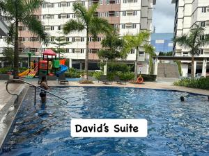 a woman is in a pool with a playground at Apartment Condotel at Hope Residences Trece Martires Cavite in Trece Martires