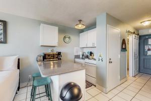 a small kitchen with a counter and a microwave at Top of the Gulf 708 in Panama City Beach