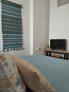a bedroom with a bed and a tv on a table at Aegina Port Apt 4 in Egina