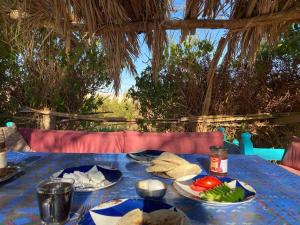 una mesa azul con platos de comida. en Beir El Gabal Hotel (with Hot Springs), en Al Qaşr