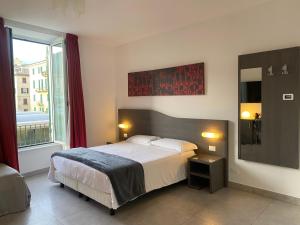 a bedroom with a bed and a large window at 54 ROSSELLI ROOMS in La Spezia