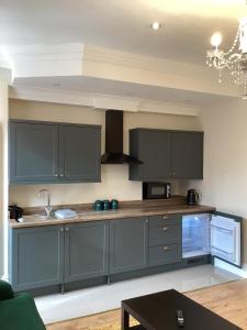 a kitchen with dark blue cabinets and a table at Aachen Hotel in Liverpool