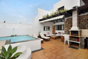 an outdoor patio with a pool and a fireplace at Casa Lancelot in Tinajo