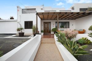 a white house with a wooden pergola at Casa Lancelot in Tinajo