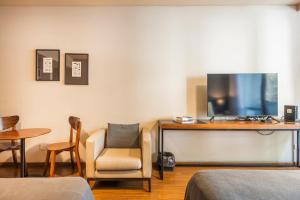 een woonkamer met een tv en een stoel bij Central Location Full Amenities heart Palermo Soho powered by Argenhost -T107- in Buenos Aires