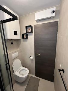 a bathroom with a toilet and a black door at Queen Hvar Luxury Apartment Jacuzzi & Bikes in Hvar +15 photos