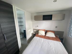 a small bedroom with a bed and a tv at mobil home 394 - Domaine de Kerlann in Pont-Aven