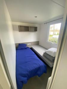una piccola camera con letto e finestra di mobil home 394 - Domaine de Kerlann a Pont-Aven