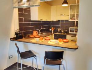 a kitchen with a counter with two chairs and a sink at Bosa Apartments Episcopio 1 in Bosa +19 photos