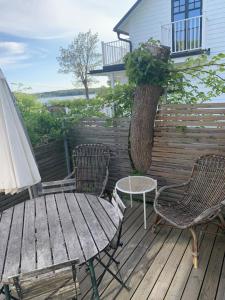 a table and chairs on a deck with a tree at Sommarvilan in Vaxholm