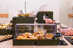 una vetrina piena di diversi tipi di prodotti da forno di Hotel Kursaal a Bellaria-Igea Marina