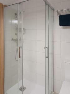 a shower with a glass door in a bathroom at Apartamento ideal en Lastres. in Colunga +9 photos