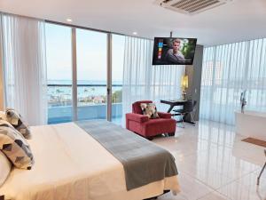 um quarto com uma cama grande e uma televisão de ecrã plano em Hotel Perla Spondylus em Manta