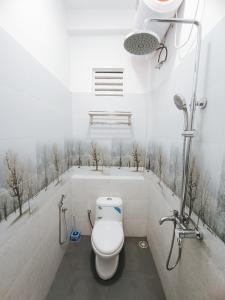een badkamer met een toilet en een douche met bomen aan de muur bij Sara Appartments in Colombo