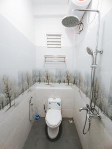 baño con aseo y ducha con árboles en la pared en Sara Appartments, en Colombo