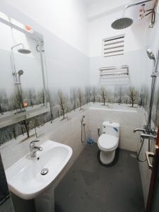 een badkamer met een witte wastafel en een toilet bij Sara Appartments in Colombo