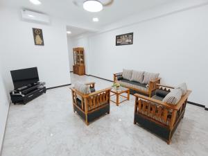 een woonkamer met verschillende banken en een piano bij Sara Appartments in Colombo