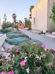 a garden with pink flowers and a sidewalk at Zeituna Lodge a Porto Cesareo in Torre Lapillo