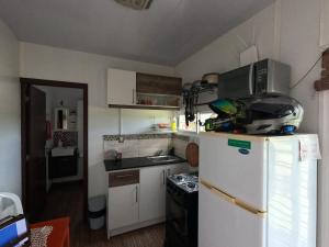 a small kitchen with a white refrigerator and a stove at La pausa in Piriápolis