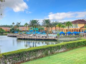 a resort with a dock with tables and blue umbrellas at Old Town Retreat At Regal Oaks By Mid Florida Home Management in Orlando