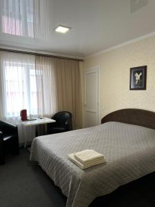 une chambre d'hôtel avec un lit, une table et une fenêtre dans l'établissement Колібрі, à Reni