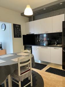 a kitchen with white cabinets and a table with chairs at Apartment Majda in Rab