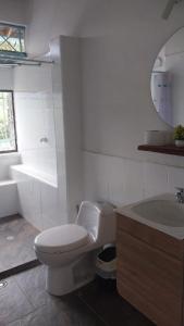 bagno bianco con servizi igienici e lavandino di Finca Villa Maria a La Pintada