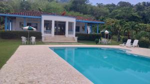 a house with a swimming pool in front of a house at Finca Villa Maria in La Pintada