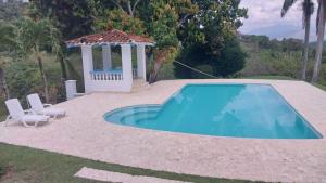 una piscina con gazebo accanto a una casa di Finca Villa Maria a La Pintada