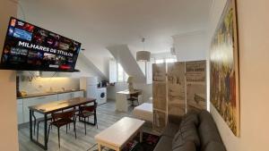 a living room with a couch and a table and a kitchen at Apartamentos Turisticos Queluz in Queluz