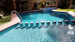 una piscina con una fila de taburetes. en Hotel Cuellar en Tula de Allende