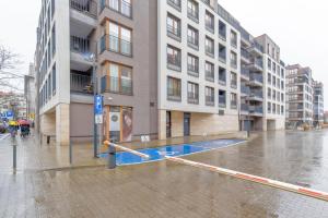 un edificio con piscina en medio de una calle en Apartament Gąsiorowskich 4 Friendly, en Poznan