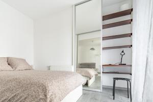 1 dormitorio con cama y espejo en Apartament Gąsiorowskich 4 Friendly, en Poznan