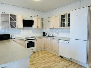 a kitchen with white appliances and wooden cabinets at aday - 4 bedrooms holiday apartment in Bronderslev in Brønderslev